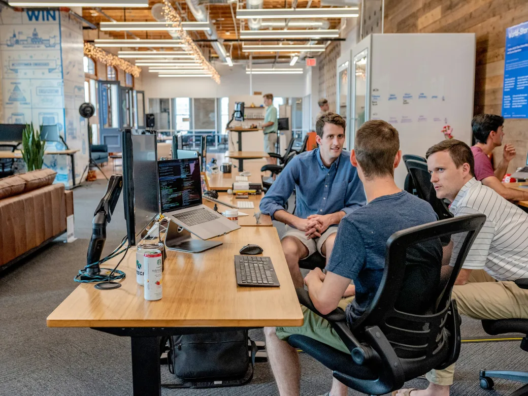A small team collaborating at a desk in a modern open-plan office