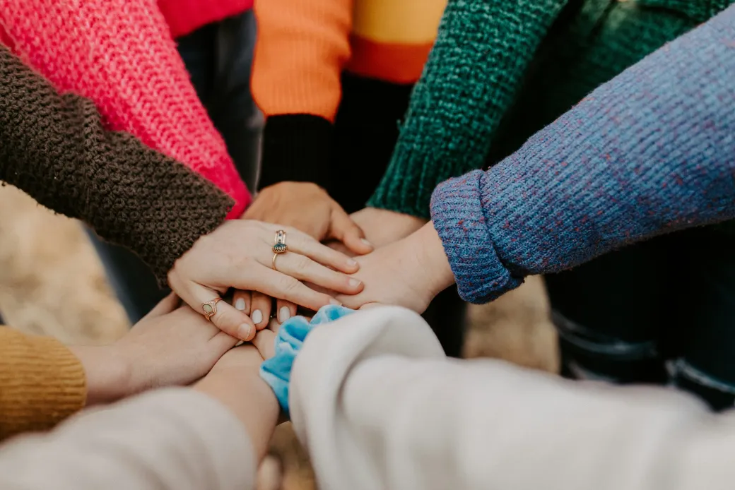 A group of friends putting their hands together